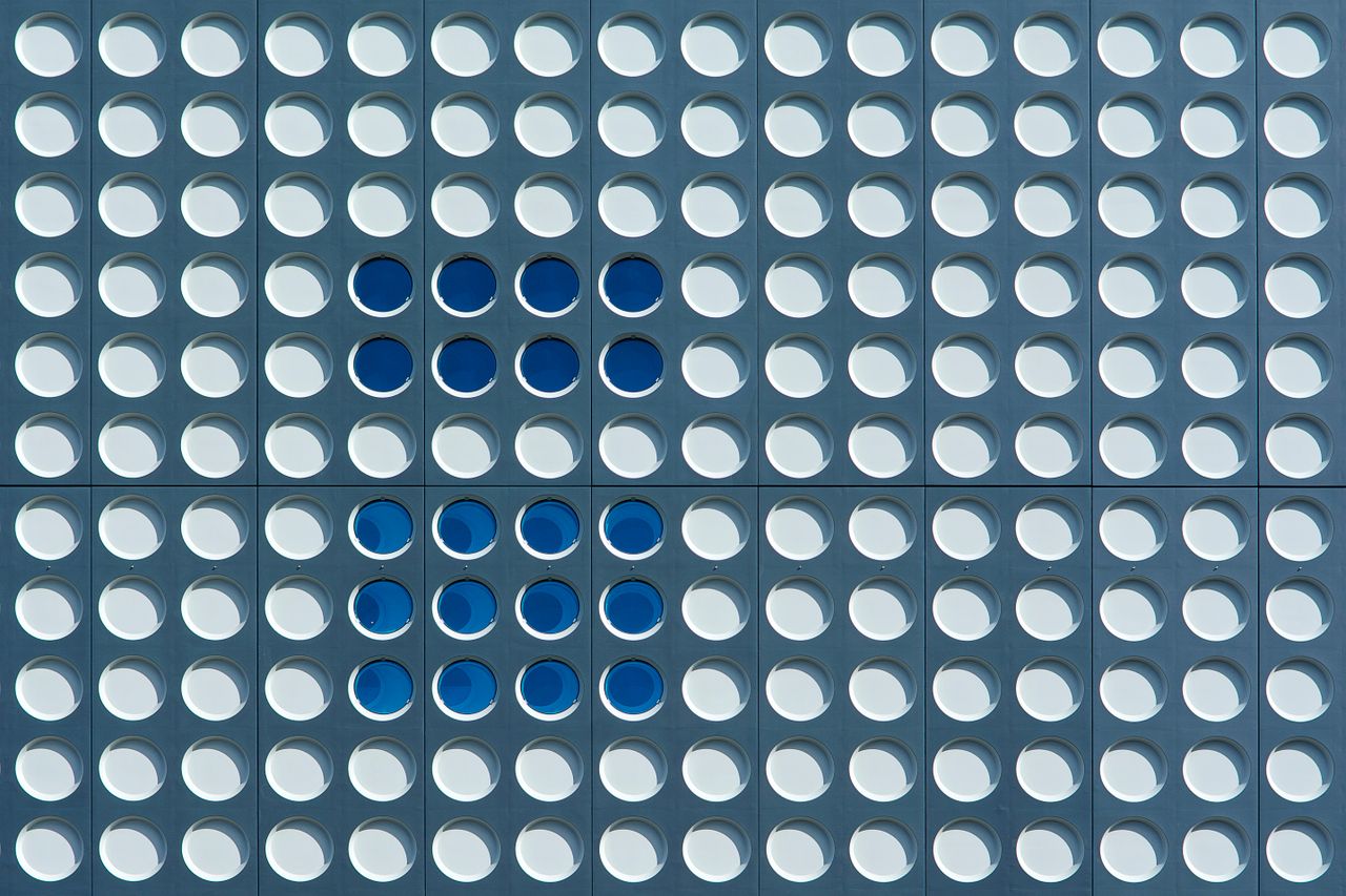 Geometric façade with circular patterns in blue and white, Utrecht architecture.